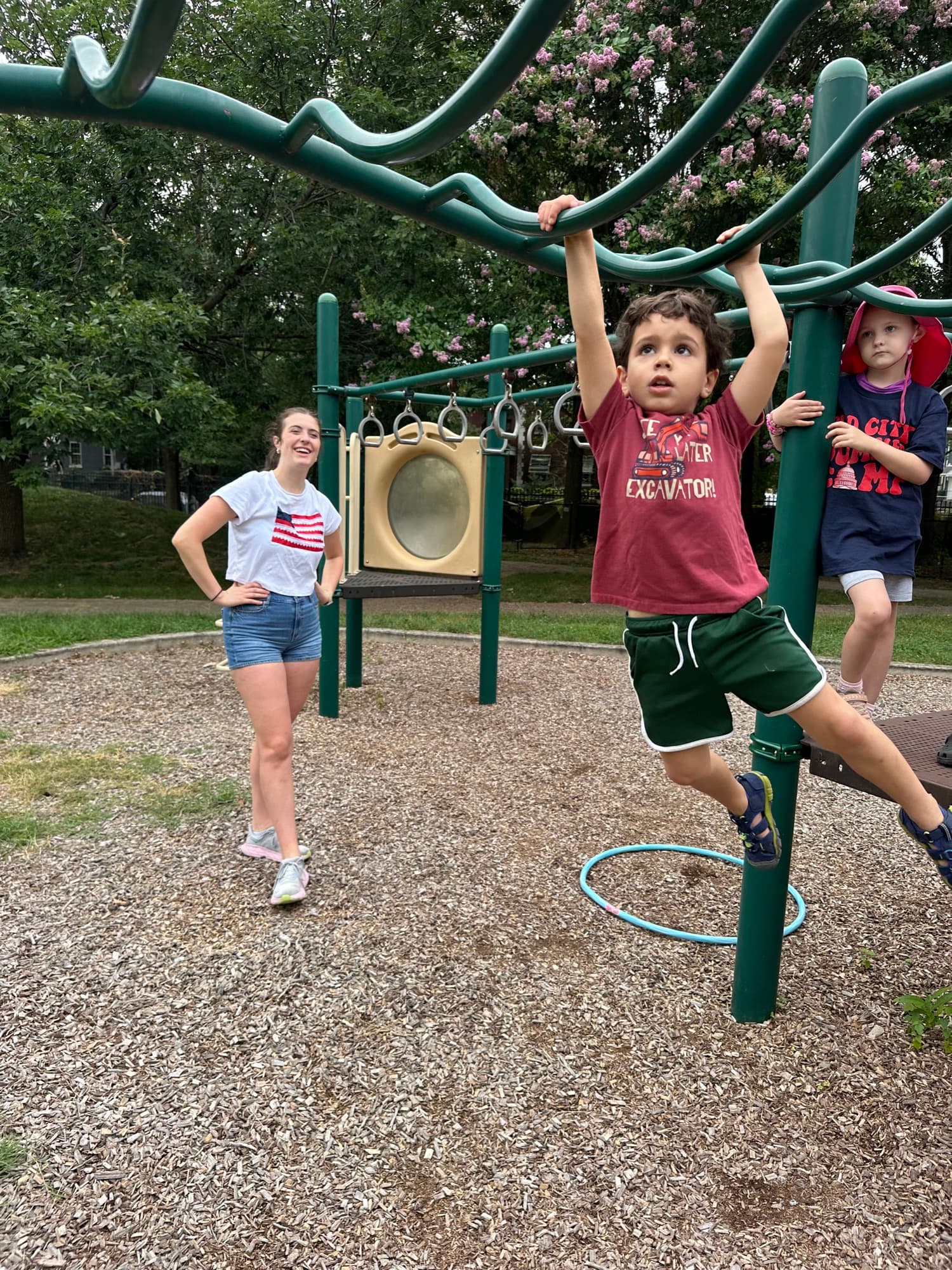 Children playing at a playground with a coach watching